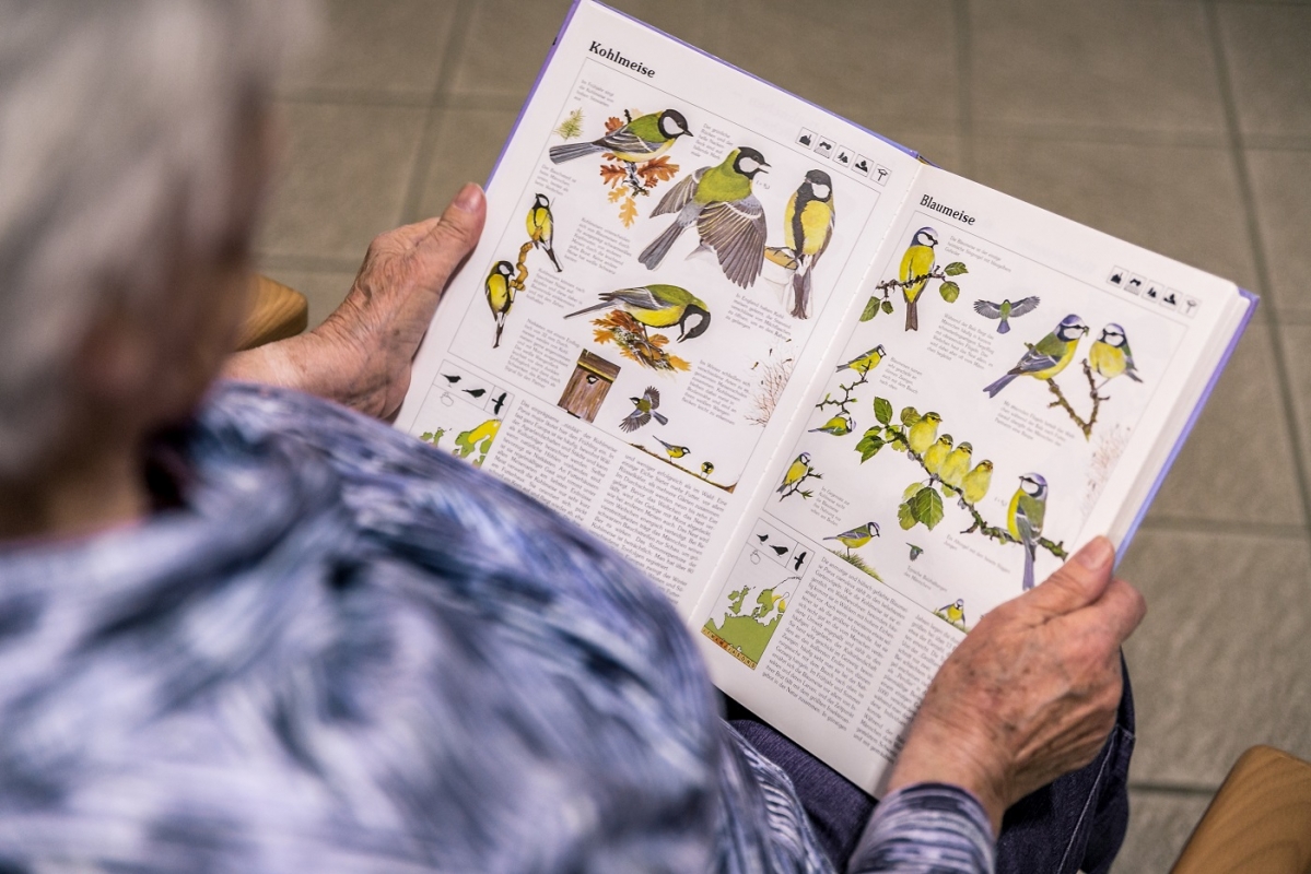 Eine Bewohnerin des Seniorenheim Reisbach freut sich über einen Bildband mit heimischen Vögeln.jpg